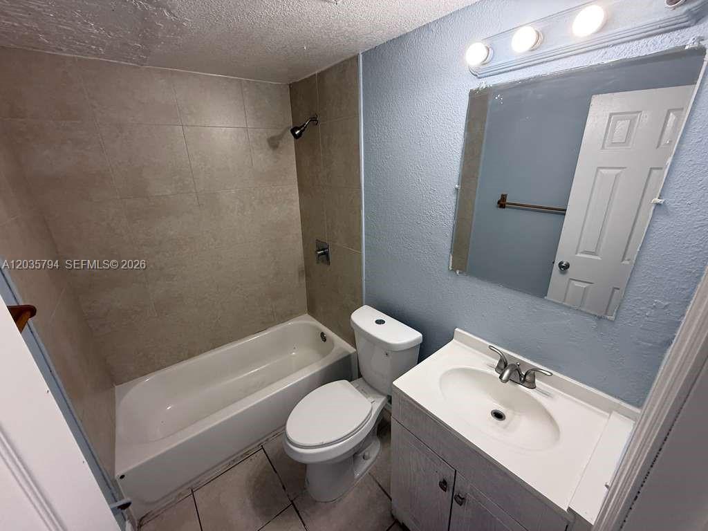 A bathroom features a tiled shower-tub combo, a white toilet, and a vanity with mirror — 2014 Funston St # C, Hollywood FL 33020, HOLLYWOOD, FL