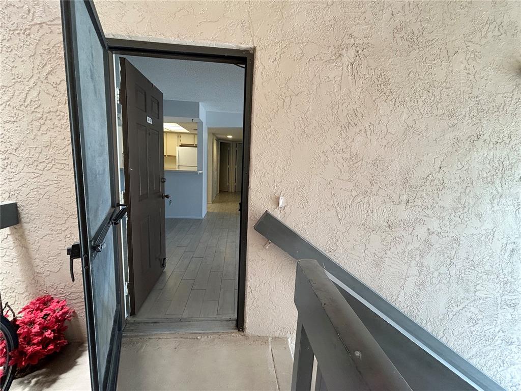 An open door reveals a view into an apartment interior with light-colored tile flooring — 19505 QUESADA AVENUE UNIT AA201, PORT CHARLOTTE, FL