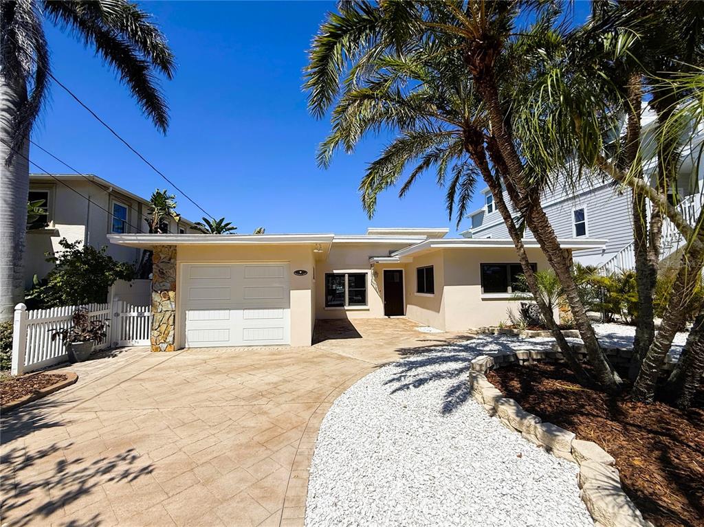 A single-story house with a white garage, stone accents, and a paved driveway — 468 20TH AVENUE, INDIAN ROCKS BEACH, FL