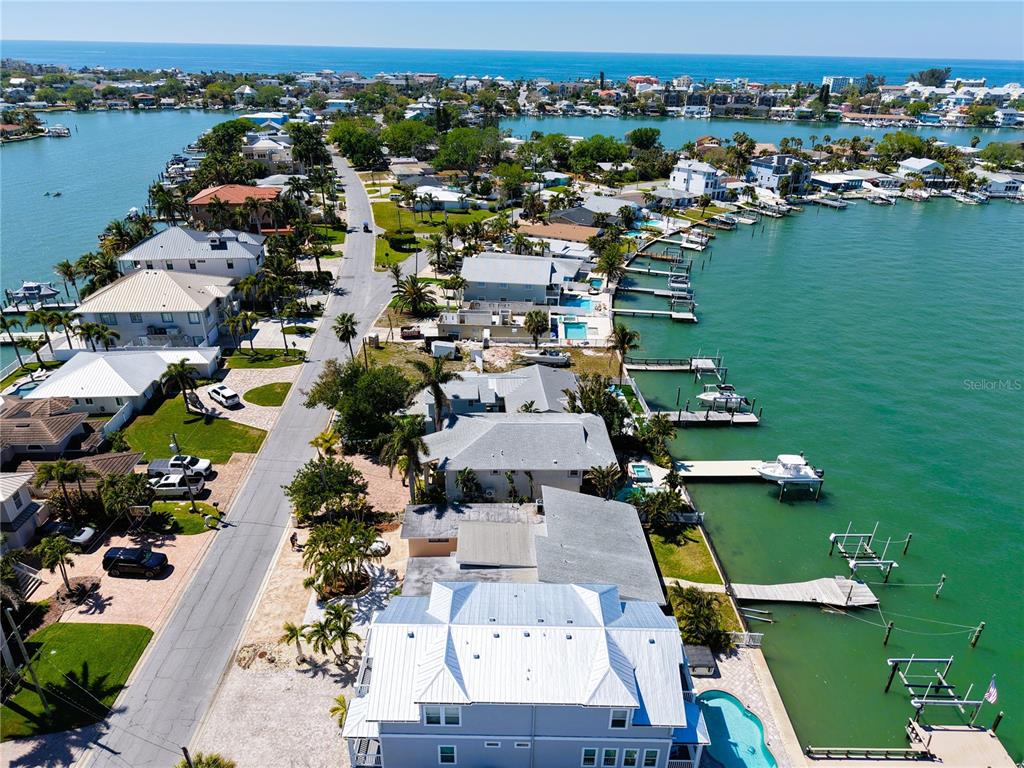 An aerial view shows waterfront homes with private docks along a narrow coastal road — 468 20TH AVENUE, INDIAN ROCKS BEACH, FL