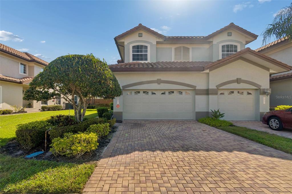 A two-story house with a paved driveway, two garage doors, and a landscaped front yard — 8235 MIRAMAR WAY, LAKEWOOD RANCH, FL
