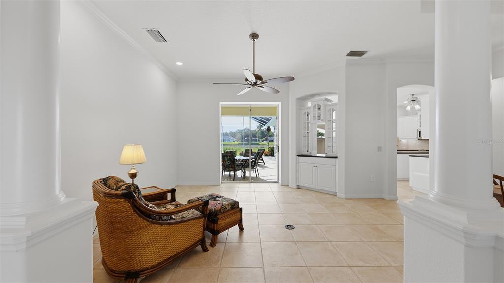A bright room with tile floors, a ceiling fan, a wicker chair, and sliding doors — 6228 AVENTURA DRIVE, SARASOTA, FL