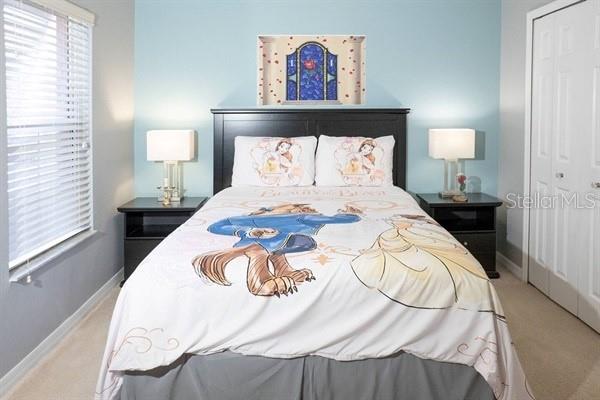 A bedroom features a bed with Beauty and the Beast bedding and matching wall art — 3163 YELLOW LANTANA LANE, KISSIMMEE, FL
