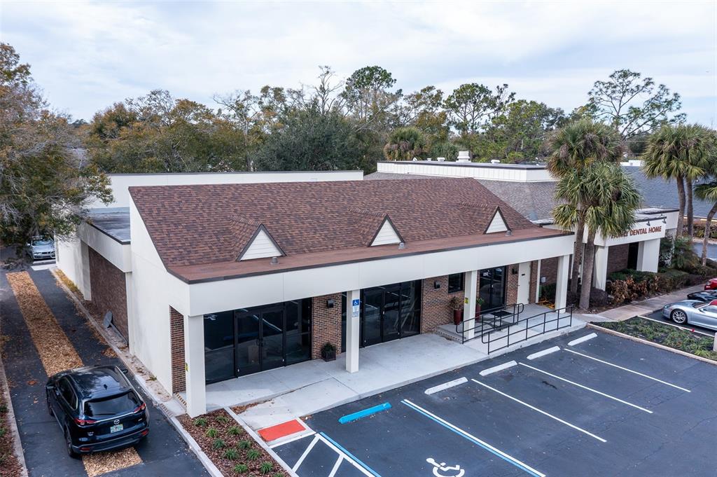 An aerial view of a commercial building with a brown shingled roof and parking — 945 STATE ROAD 436 UNIT B and C, CASSELBERRY, FL