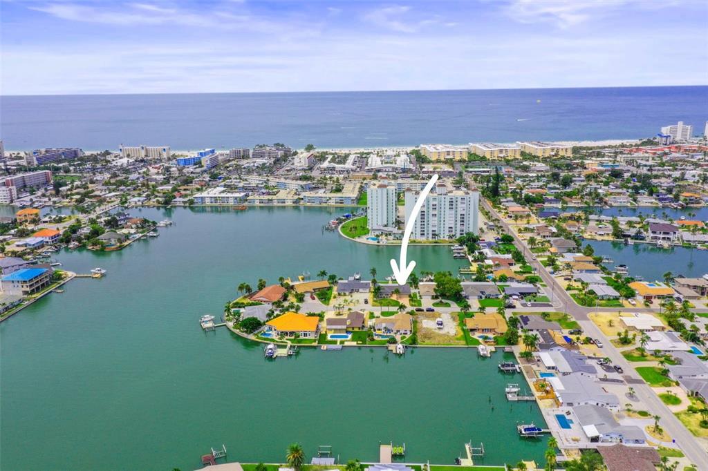 An aerial view shows a waterfront residential neighborhood with a white arrow pointing to a house — 6360 2ND PALM POINT, ST PETERSBURG, FL