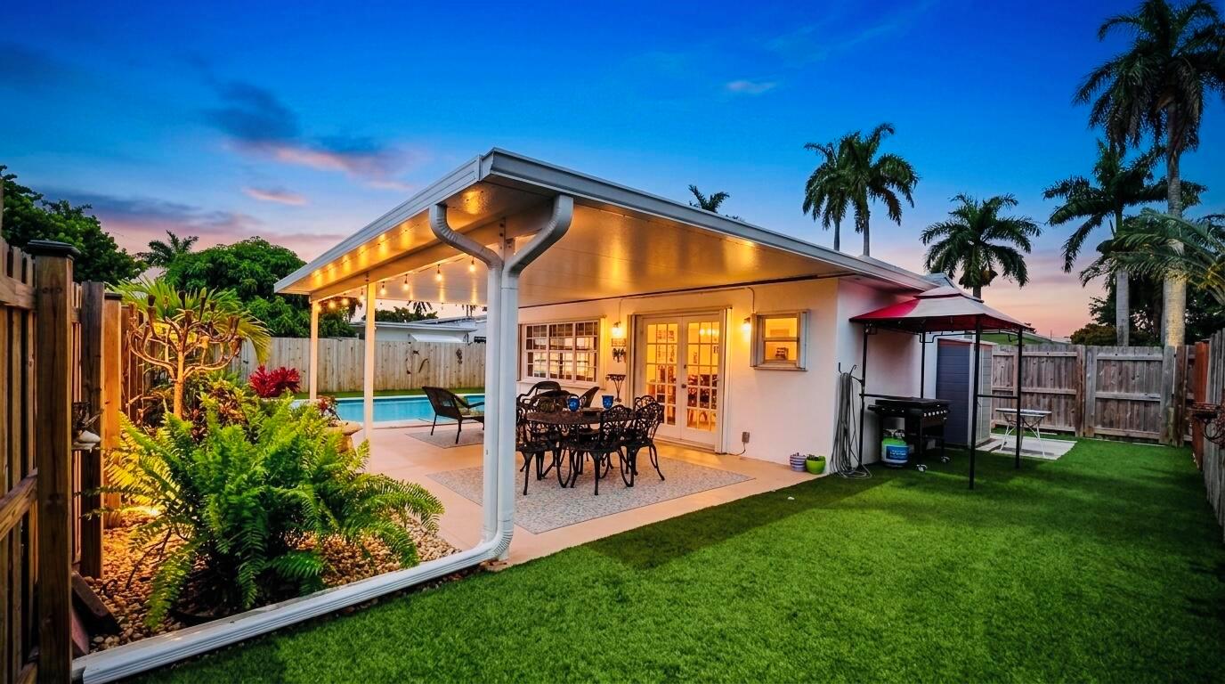 A backyard patio features a covered seating area, a swimming pool, and artificial grass — 707 N 32nd Avenue, Hollywood FL 33021, HOLLYWOOD, FL