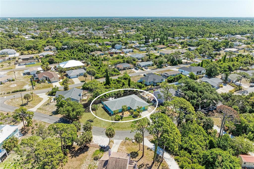 An aerial view shows a single-story house with a hip roof in a residential neighborhood — 1184 KENISCO ROAD, VENICE, FL