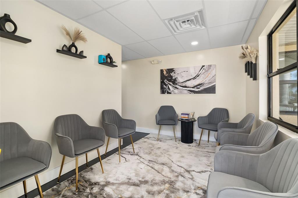 A waiting room features grey upholstered chairs, a marble-patterned rug, and minimalist wall decor — 1900 TAMIAMI TRAIL UNIT C & D, PUNTA GORDA, FL