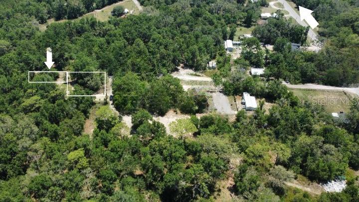 An aerial view shows a wooded lot with white outlines marking potential building sites — 17308 PUTTER LANE, SPRING HILL, FL