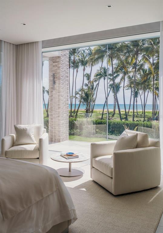 A bedroom with two white armchairs and a round table facing a floor-to-ceiling ocean view — Ocean Drive FOUR SEASONS PRIVATE RESIDENCES UNIT 6101, RIO GRANDE, PR