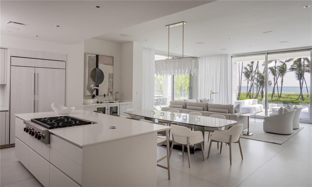 A modern open-concept kitchen and dining area features white cabinetry, a large island, and oceanfront views — Ocean Drive FOUR SEASONS PRIVATE RESIDENCES UNIT 6101, RIO GRANDE, PR