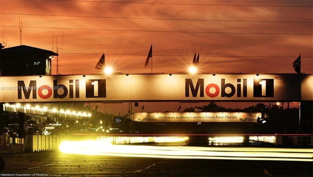 A Mobil 1 bridge spans a racetrack at sunset with bright light streaks on the track — 2124 Abington, Sebring FL 33875, SEBRING, FL