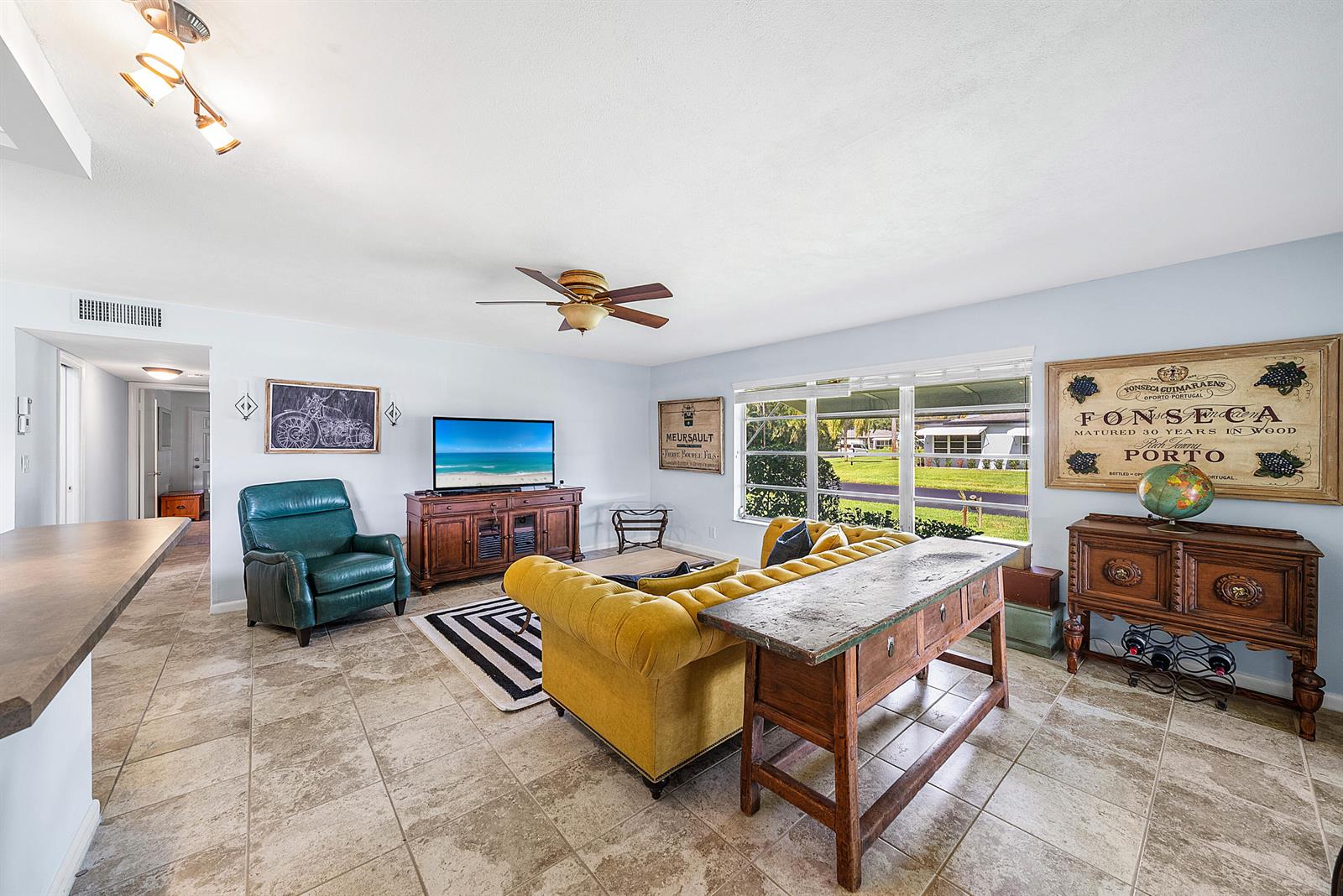 A galley kitchen features wood cabinets, stainless steel appliances, and a breakfast bar counter — 510 High Point Drive # D, Delray Beach FL 33445, DELRAY BEACH, FL