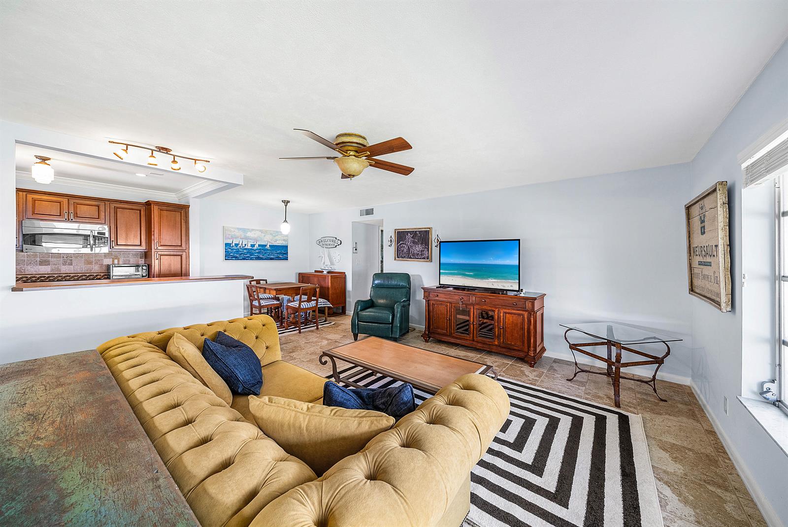 A kitchen features wood cabinets, stainless steel appliances, a tiled backsplash, and a window view — 510 High Point Drive # D, Delray Beach FL 33445, DELRAY BEACH, FL