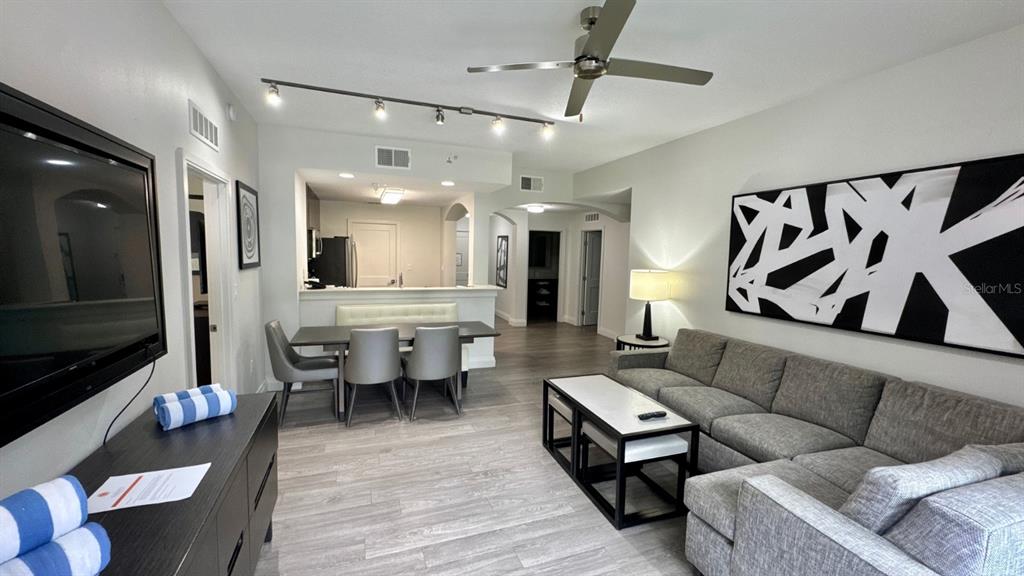 A living room and dining area feature gray tile floors, a sectional sofa, and track lighting — 14501 GROVE RESORT AVENUE UNIT 3202, WINTER GARDEN, FL