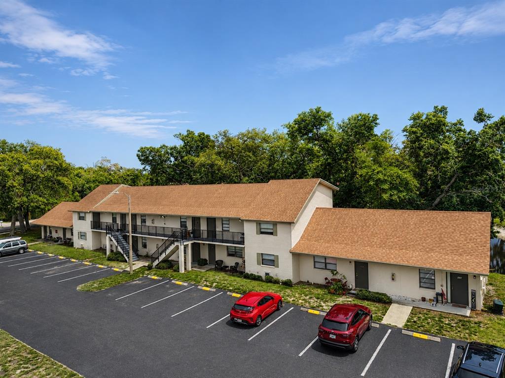 An exterior view of a two-story apartment building with a parking lot in front — 2142 BRADFORD STREET UNIT 308, CLEARWATER, FL
