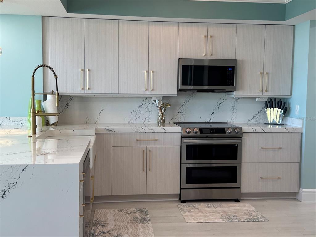 An entryway features light blue walls, symmetrical console tables, wall sconces, and a central door — 200 OCEAN CREST DRIVE UNIT 1112, PALM COAST, FL