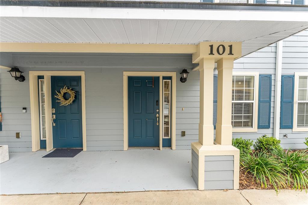 A covered porch features two blue front doors and a pillar labeled with number 101 — 2980 SW 35TH PLACE UNIT 101, GAINESVILLE, FL