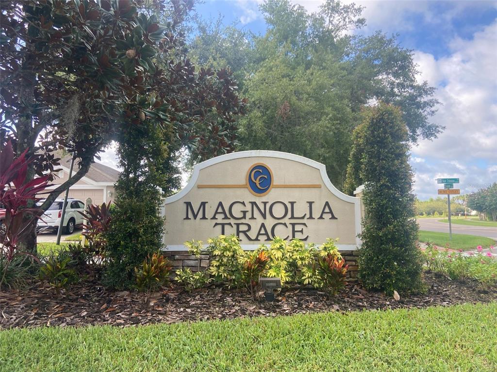 A stone and stucco monument sign for Magnolia Trace stands in a landscaped garden — 10542 SAN TRAVASO DRIVE, TAMPA, FL