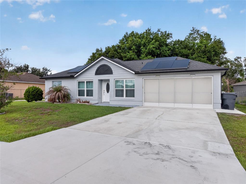 A dining area with a textured accent wall and modern light fixture opens to a kitchen — 610 JAGUAR COURT, KISSIMMEE, FL