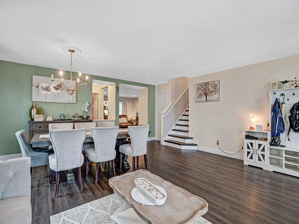 A dining area with a green accent wall, wooden floors, and stairs leading to an upper level — 16755 SUNRISE VISTA DRIVE, CLERMONT, FL