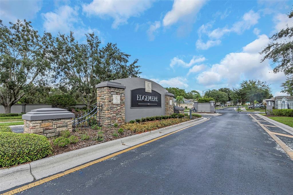 A stone-accented monument sign marks the gated entrance to the Edgemere community — 14818 EDGEMERE DRIVE, SPRING HILL, FL