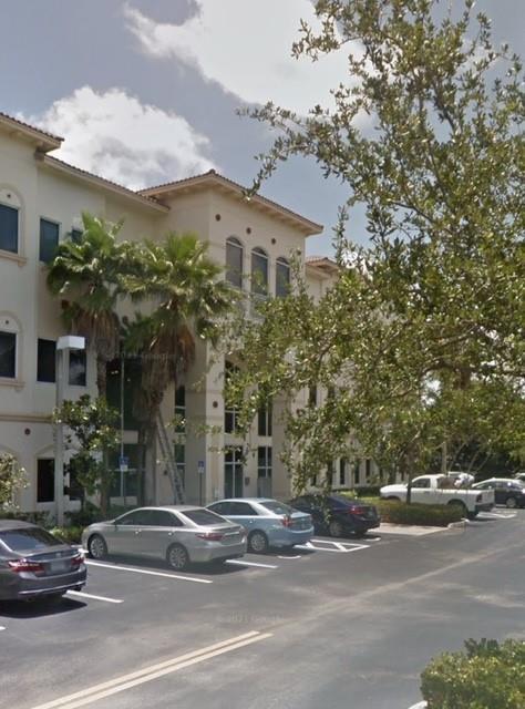 A multi-story commercial building with a beige facade and parking lot in the foreground — 2893 Executive Park Drive # 106, Weston FL 33331, WESTON, FL