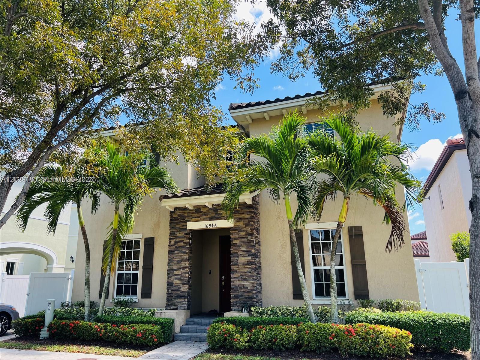 A two-story stucco house features a stone-accented entryway, palm trees, and a landscaped front yard — 16946 SW 90th Terrace Circle, Miami FL 33196, MIAMI, FL