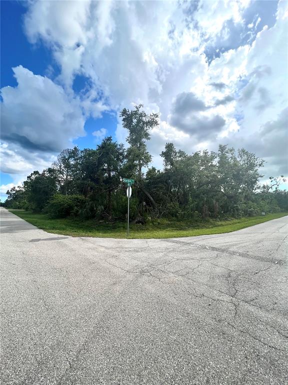 A street corner with a road intersection and a wooded lot featuring a street sign — 18235 VARDON AVENUE, PORT CHARLOTTE, FL