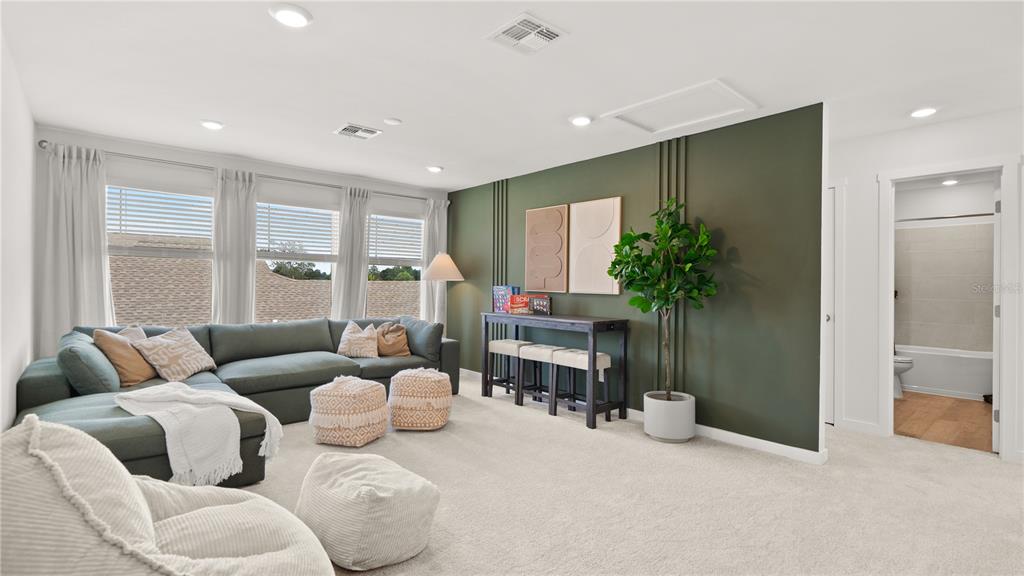 A living room features a green accent wall, a sectional sofa, and a console table — 4161 EASTMINSTER ROAD, DAVENPORT, FL