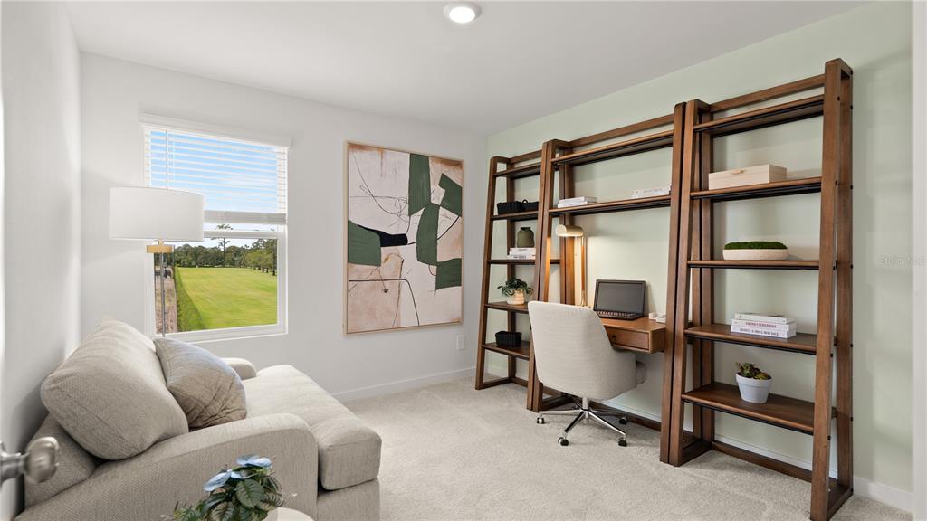 A home office features a desk with shelving, a sofa, and a window overlooking grass — 4161 EASTMINSTER ROAD, DAVENPORT, FL