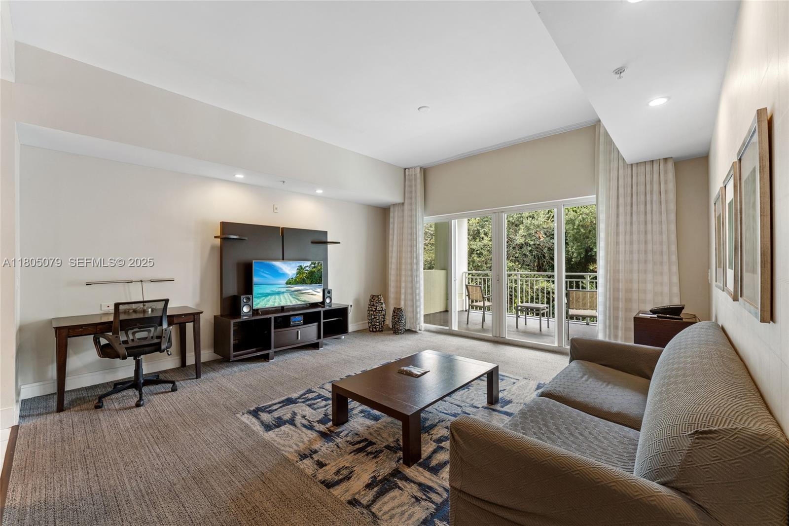 A living room features a desk, television console, coffee table, sofa, and a balcony view — 5300 NW 87th Ave # 1513, Doral FL 33178, DORAL, FL