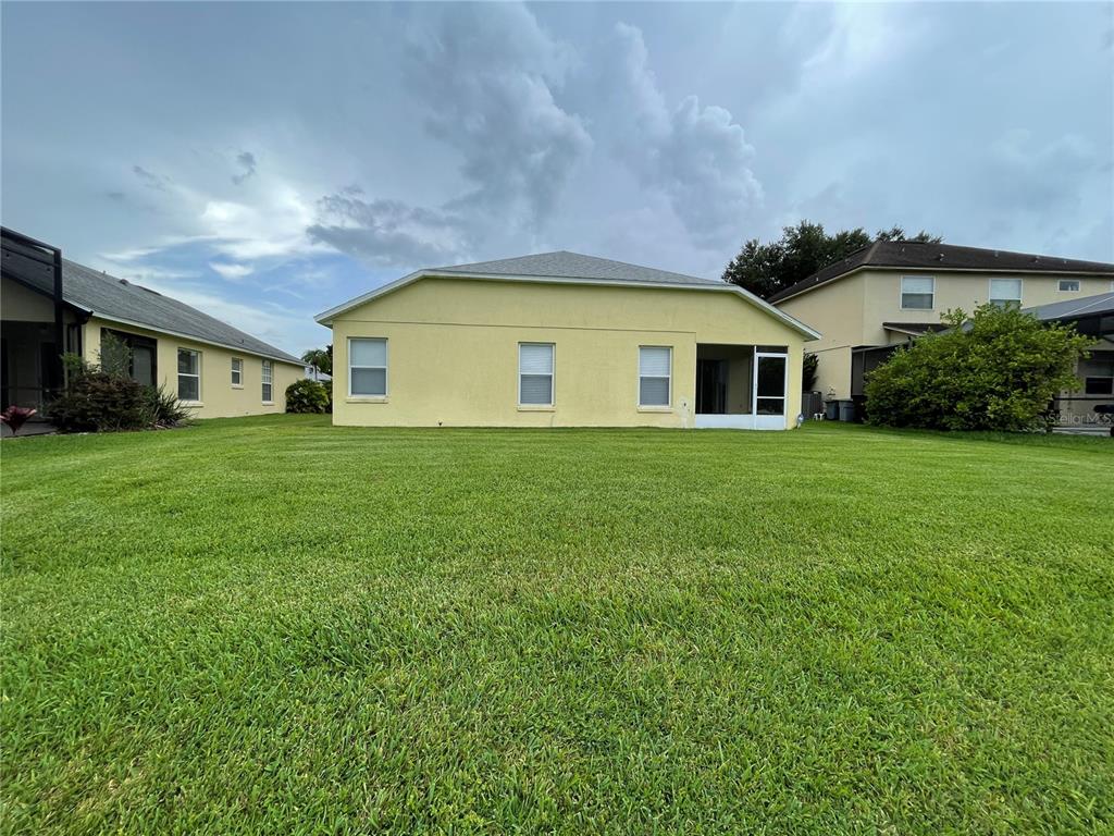 A view of the yellow stucco exterior of a house from the backyard — 4219 ANDOVER CAY BOULEVARD, ORLANDO, FL