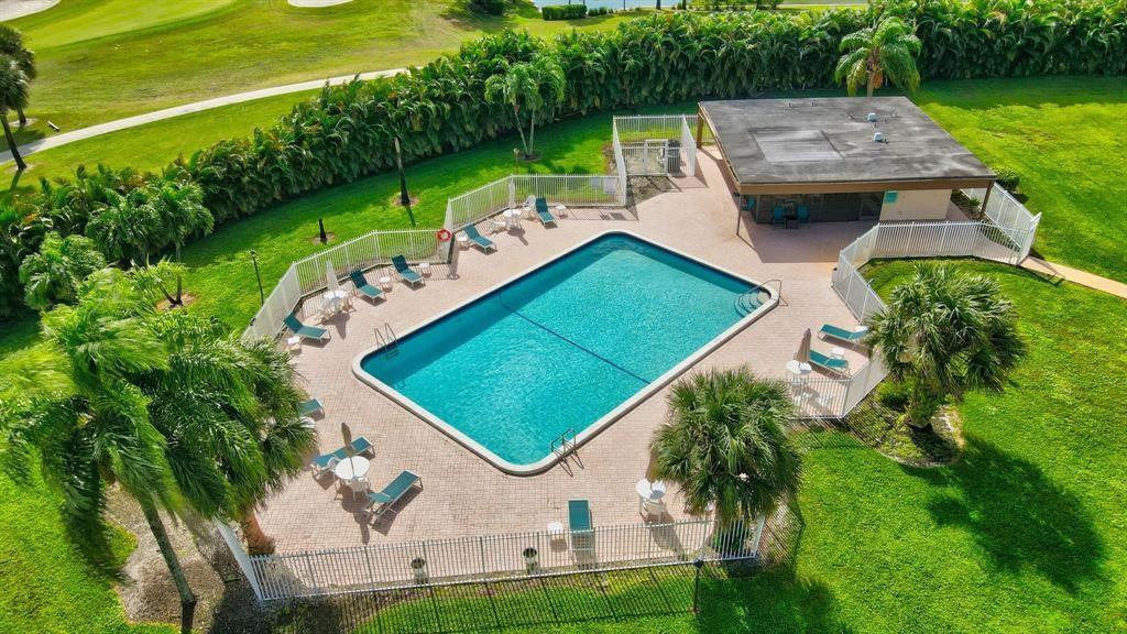 An aerial view of a rectangular swimming pool surrounded by a patio, fence, and landscaping — 9300 SW 8th Street # 422, Boca Raton FL 33428, BOCA RATON, FL