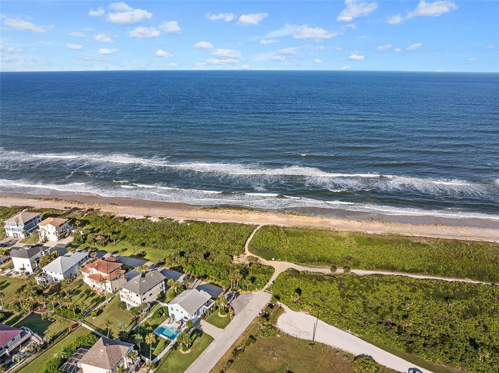 An aerial view shows coastal homes near a sandy beach and the ocean — 12 LAUREL DRIVE, PALM COAST, FL