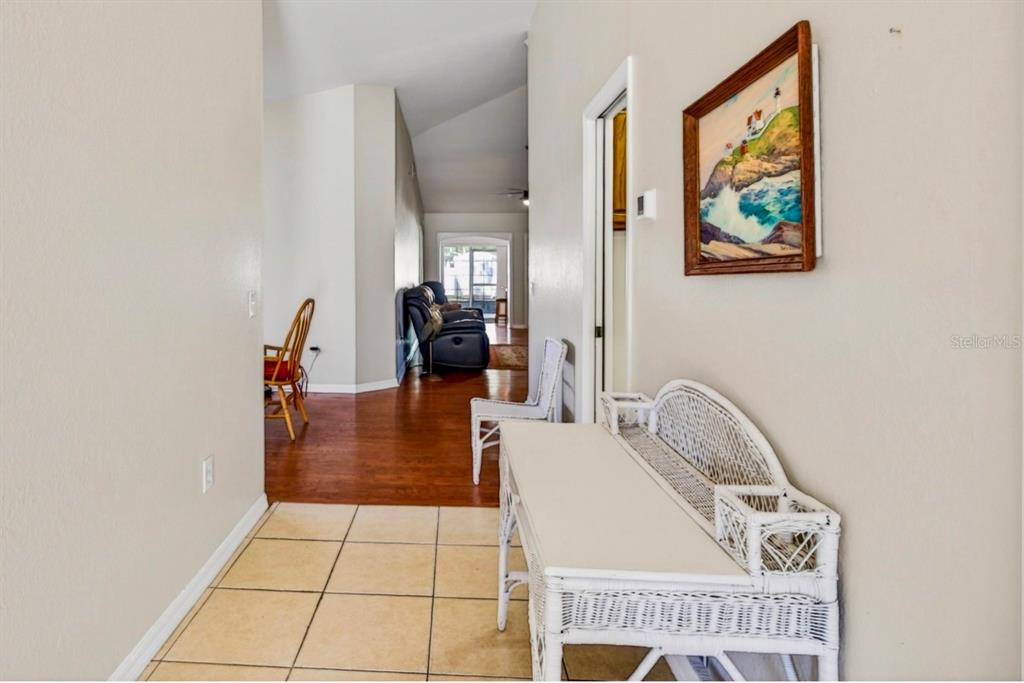 A tiled entryway leads into a living area with hardwood floors and a white console — 35653 CALLA COURT, LEESBURG, FL