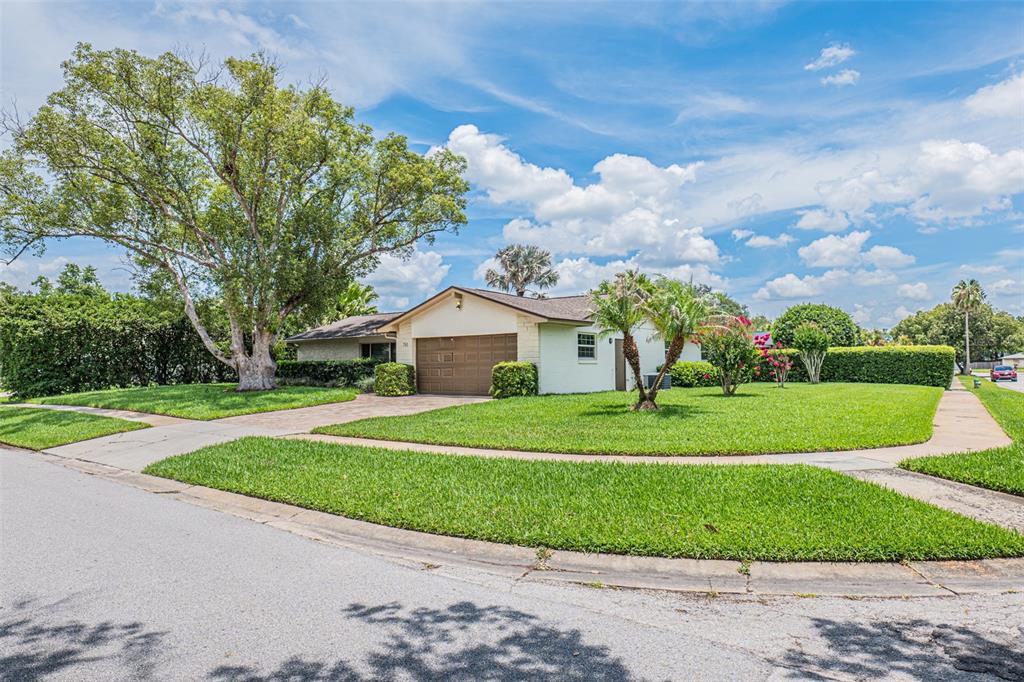 A single-story house with a brown garage door sits on a corner lot with trees — 741 BROOKSIDE ROAD, MAITLAND, FL