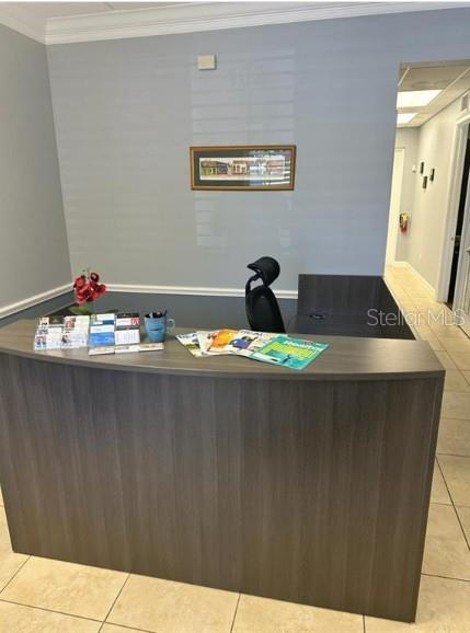 A reception desk with brochures and a chair sits in a professional office space — 5245 OFFICE PARK BOULEVARD UNIT 102, BRADENTON, FL