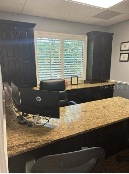 A home office features dark wood cabinetry, a granite desk, and a window with shutters — 5245 OFFICE PARK BOULEVARD UNIT 102, BRADENTON, FL