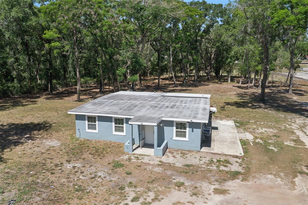 An aerial view of a single-story gray house situated on a large, wooded lot — 3932 WHITE HERON DRIVE, ORLANDO, FL