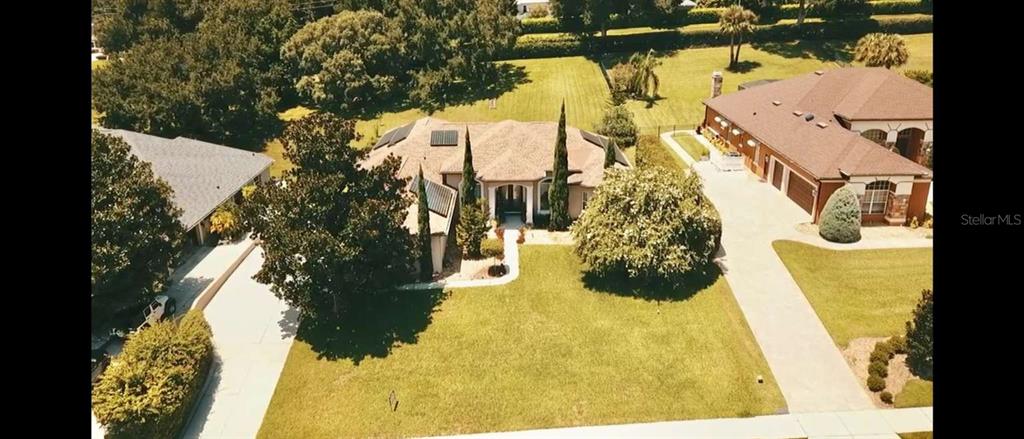 An aerial view shows a residential house with a large lawn and paved driveways — 16325 MAGNOLIA BLUFF DRIVE, MONTVERDE, FL