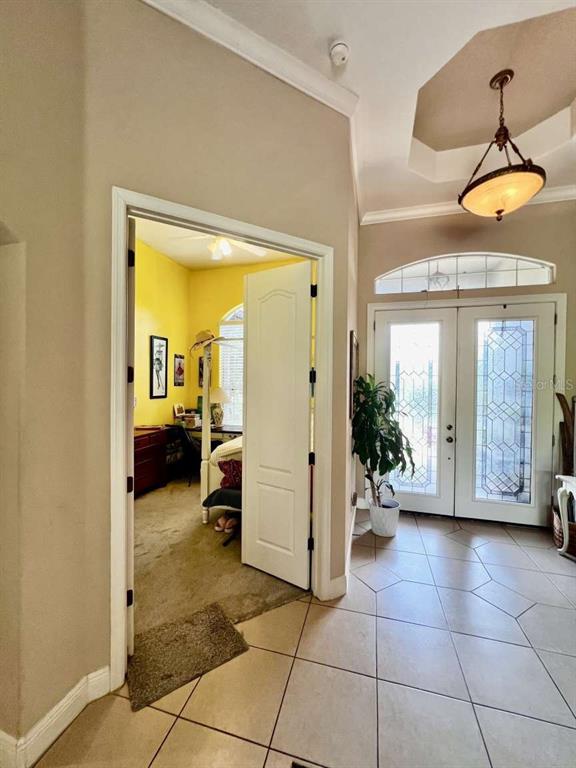 A foyer with tile floors leads to a yellow bedroom through an open doorway — 16325 MAGNOLIA BLUFF DRIVE, MONTVERDE, FL