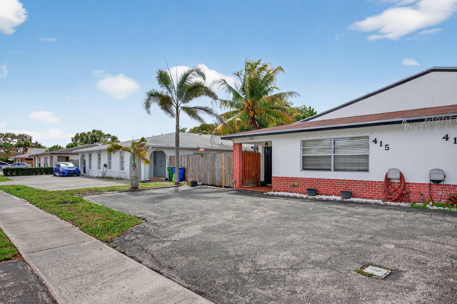 A single-story house with a white facade, red brick base, and a paved driveway — 415 SW 61st Terrace, Margate FL 33068, MARGATE, FL