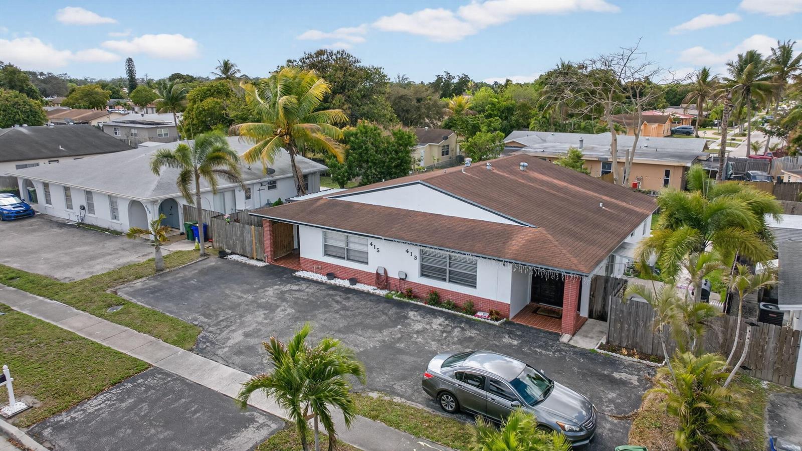 An aerial view shows a single-story duplex with a brown roof and a large asphalt driveway — 415 SW 61st Terrace, Margate FL 33068, MARGATE, FL