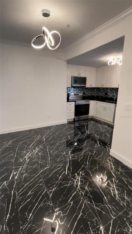 A kitchen and dining area feature black marble-patterned tile flooring and white cabinetry — 501 KNIGHTS RUN AVENUE UNIT 2106, TAMPA, FL