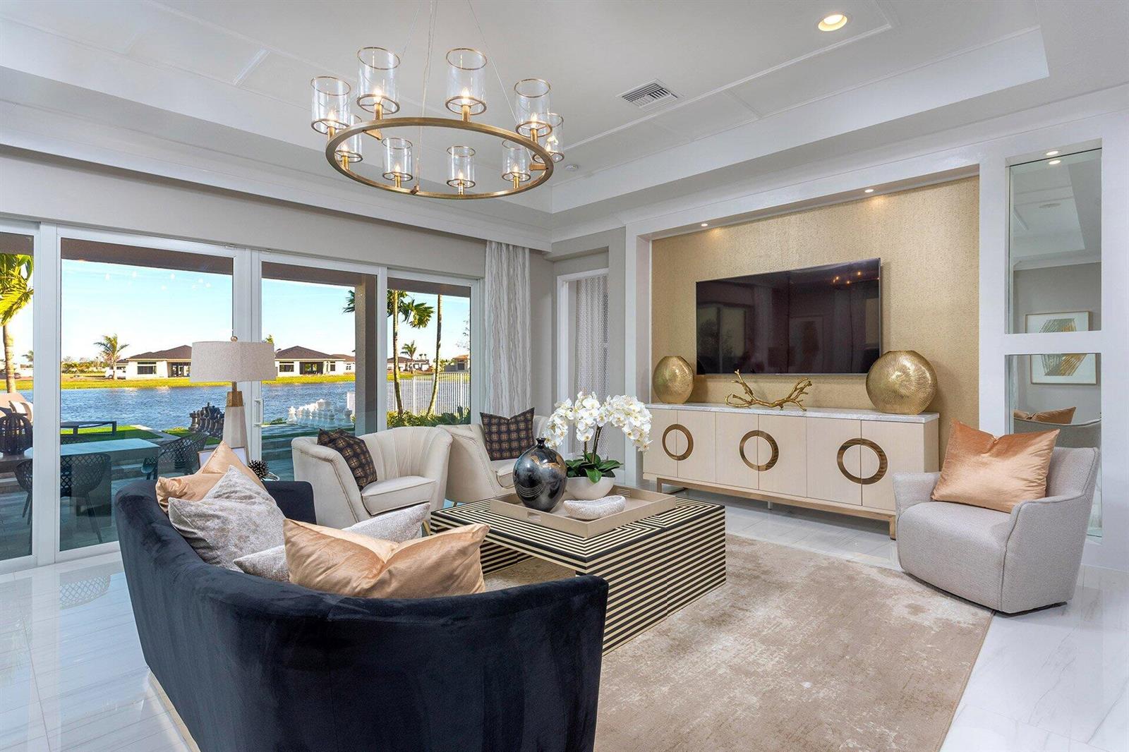A modern kitchen features white cabinetry, a large central island with seating, and pendant lighting — 11311 Virginia Pine Court, Boynton Beach FL 33473, BOYNTON BEACH, FL