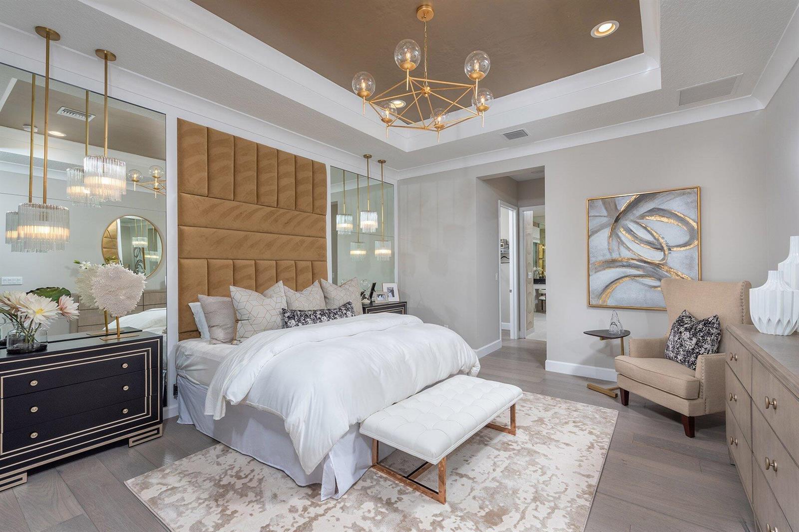A bedroom features a tufted headboard, two wooden nightstands, a chandelier, and a bench — 11311 Virginia Pine Court, Boynton Beach FL 33473, BOYNTON BEACH, FL