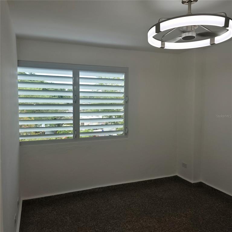 An empty room features white walls, a speckled floor, and a modern circular ceiling light — 424 CALLE ENSENADA UNIT 307, SAN JUAN, PR