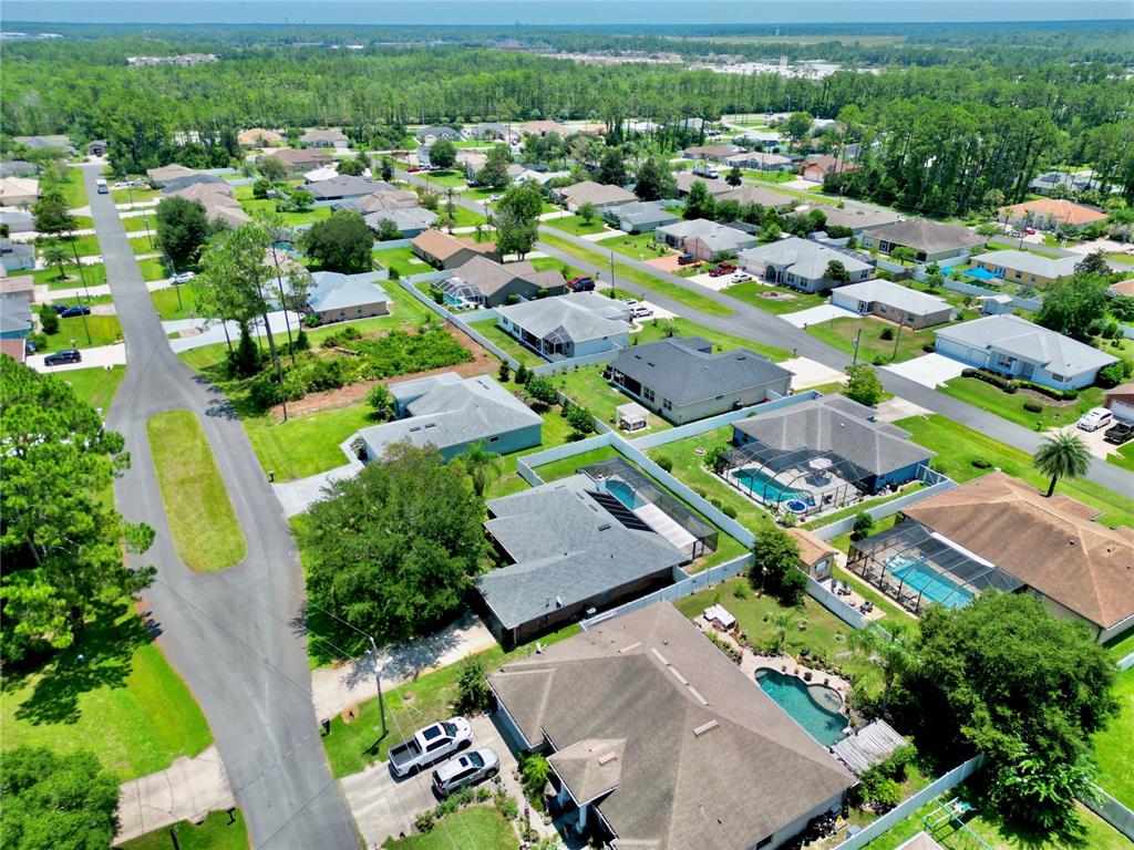 An aerial view of a suburban neighborhood featuring houses with swimming pools and paved streets — 12 EASTMOOR LANE, PALM COAST, FL