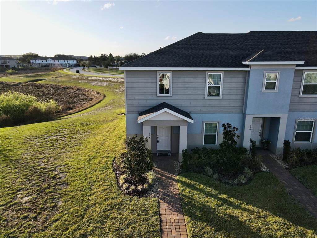 An aerial view of a two-story townhouse with gray siding and a brick walkway — 124 PRIMROSE DRIVE, DAVENPORT, FL